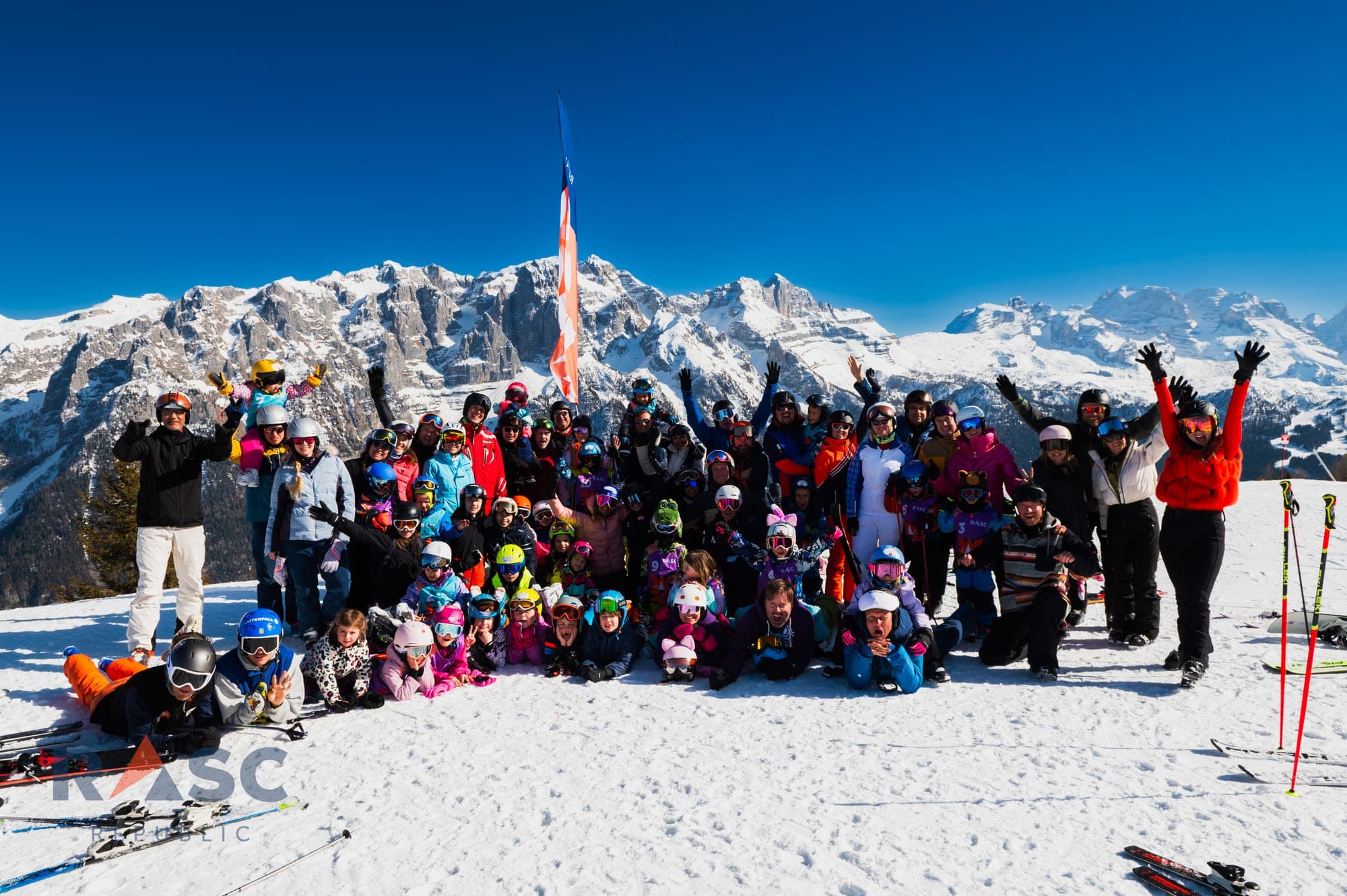 Grupa wyjazdowa RASC Republic na szczycie stoku, w tle ośnieżone Dolomity