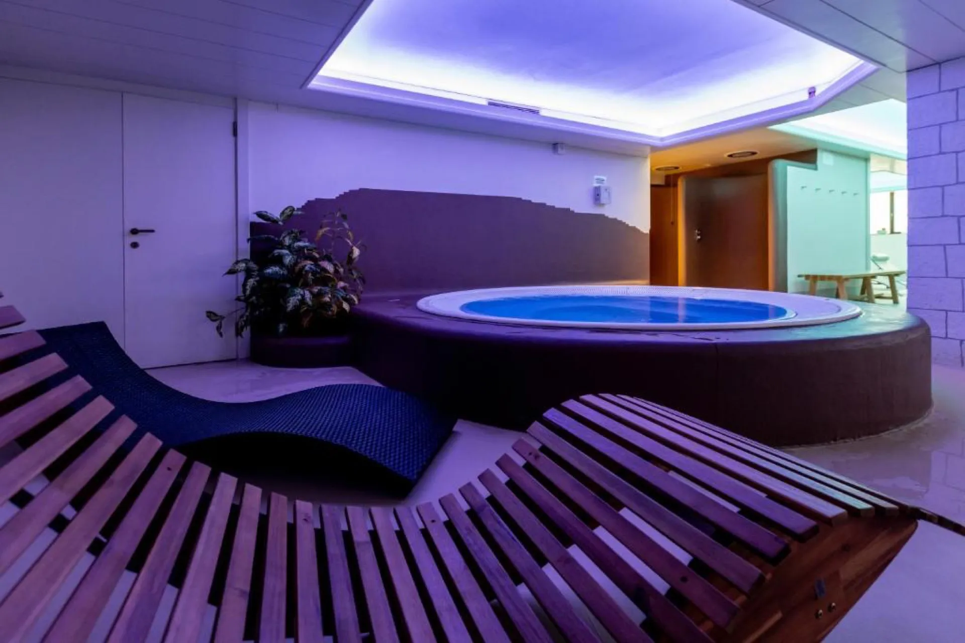 Jacuzzi z hydromasażem w strefie SPA hotelu Venezia, obok drewniane leżanki