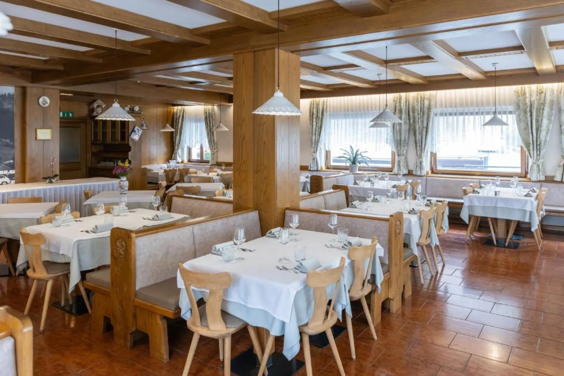 Hotelowa restauracja z drewnianym stropem, stoły nakryte białymi obrusami