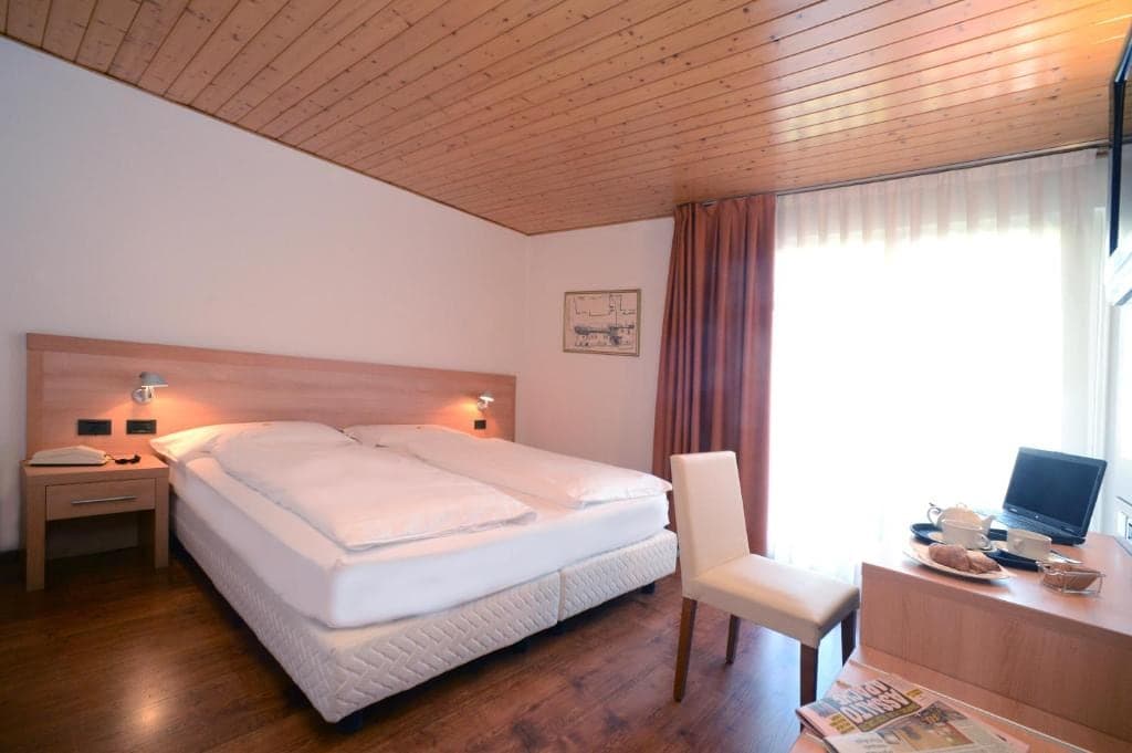 Pokój dwuosobowy w hotelu Los Andes z drewnianym sufitem i oknem z zasłonami