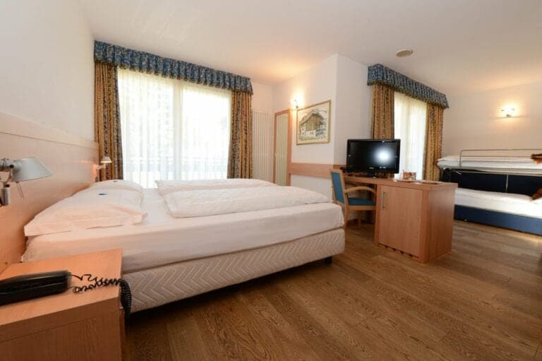 Pokój w hotelu Los Andes z drewnianą podłogą, podwójnym łóżkiem i telewizorem