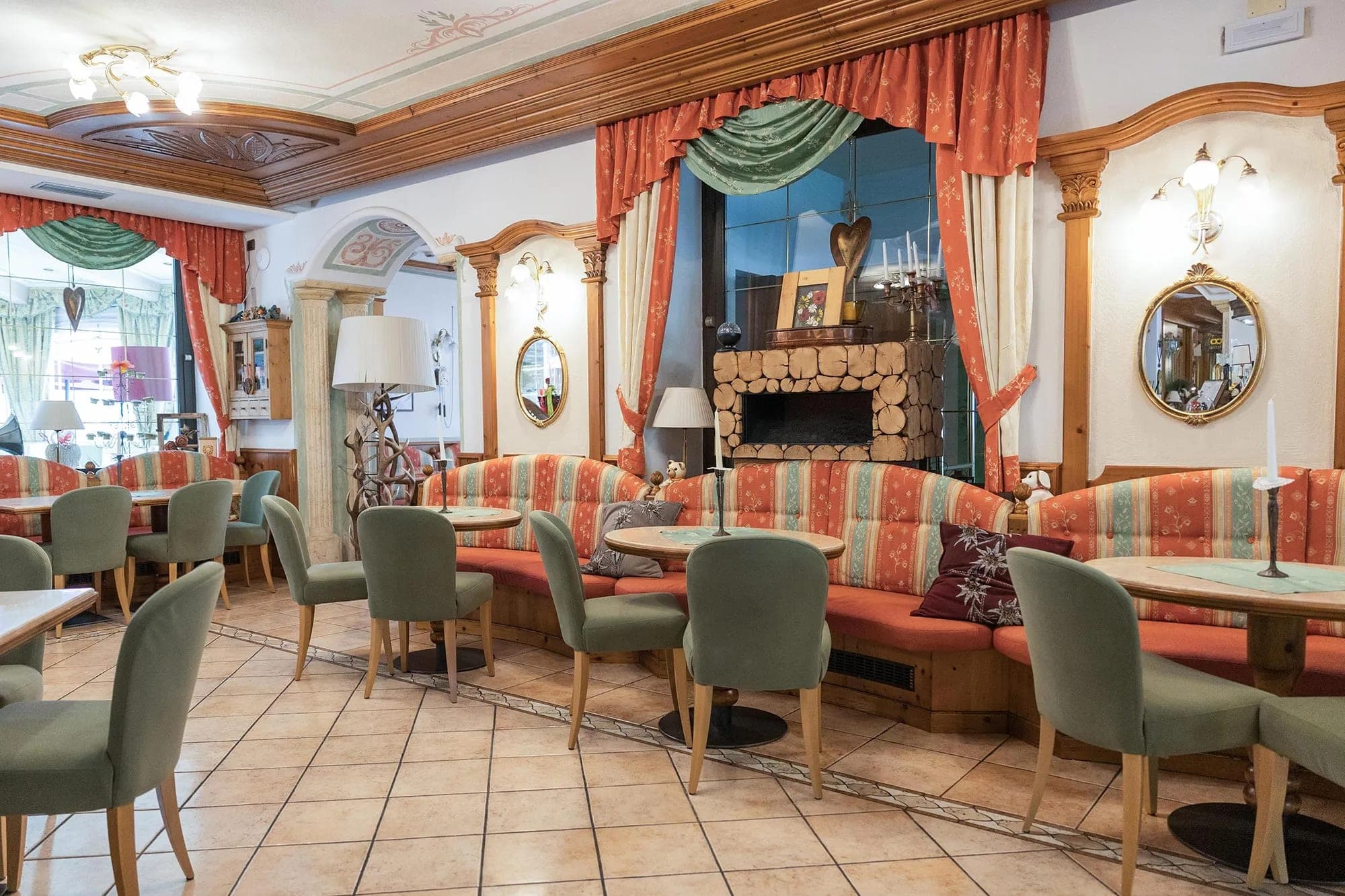 Hotelowy salon z kominkiem, kanapami w pasy i drewnianą zabudową w alpejskim stylu