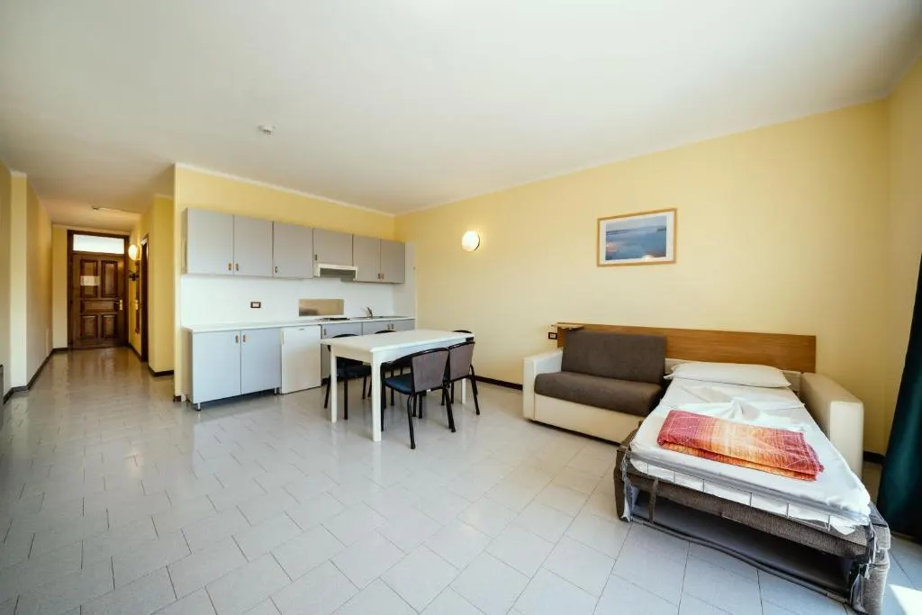 Pokój dzienny apartamentu z aneksem kuchennym, stolikiem i rozkładaną sofą