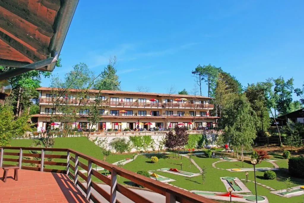 Pole do mini golfa na trawniku przed budynkiem hotelu, widziane z tarasu