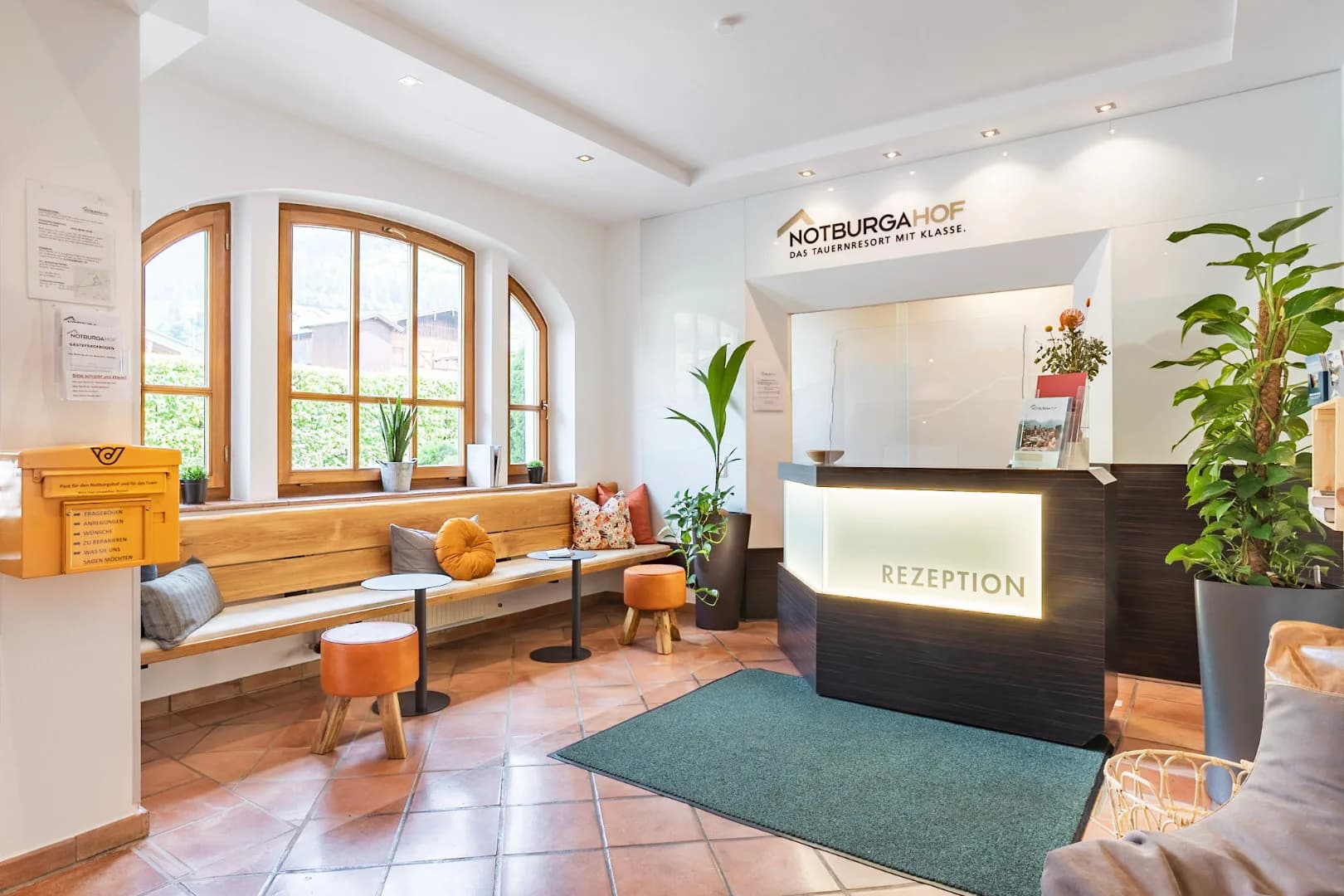 Recepcja hotelu Notburgahof z drewnianą ladą i ławą pod oknem