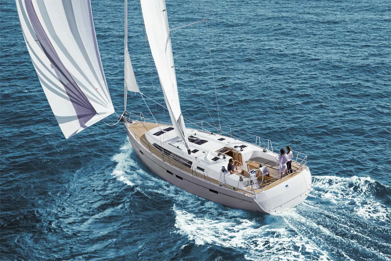Jacht Bavaria Cruiser 46 pod żaglami na otwartym morzu, widziany z góry, załoga w kokpicie na rufie