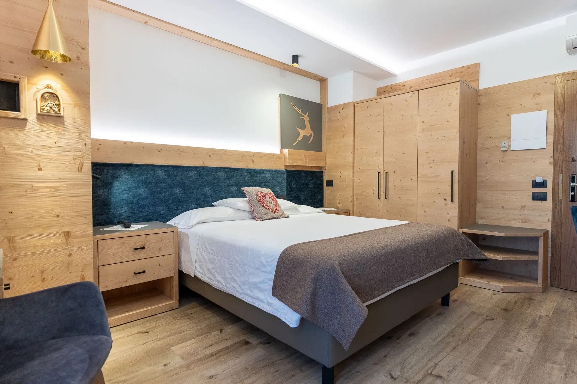 Odnowiony pokój Comfort w hotelu Alexander, jasne drewno na ścianach i podwójne łóżko
