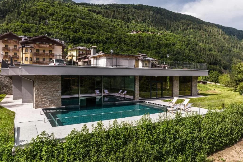 Budynek Gaia Wellness Residence z zewnętrznym basenem i tarasem, w tle zalesione zbocze