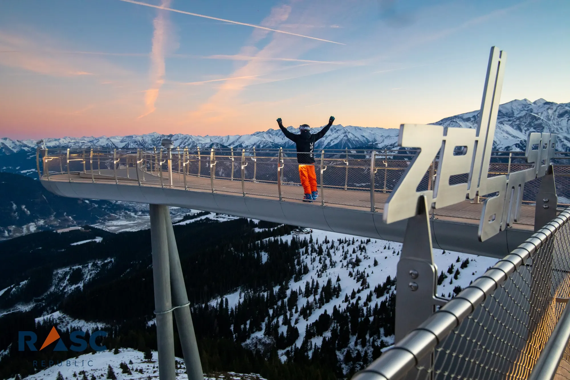Taras widokowy nad Zell am See o zachodzie słońca, w tle ośnieżone szczyty